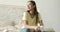 Portrait smiling happy woman with prosthetic arm sitting on bed at home, girl with disability artificial prosthetic limb