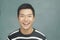 Portrait of smiling, happy young man in front of blackboard