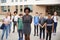 Portrait Of Smiling High School Student Group With Female Teacher Standing Outside School Buildings