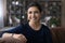 Portrait of smiling Indian female renter relax at home