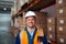 Portrait of a smiling industrial male worker standing in warehouse looking at camera