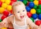 Portrait of a smiling infant among colorful balls