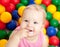 Portrait of a smiling infant among colorful balls