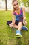 Portrait of smiling jogger woman tying shoelace