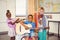 Portrait of smiling kids playing guitar, violin, flute in classroom