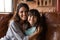 Portrait of smiling Latino mom cuddle with daughter