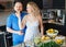 Portrait of smiling laughing white Caucasian couple two people pregnant woman with husband cooking food, eating citrus