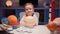 Portrait smiling little blond boy sitting at home at table near planet Saturn around many planets of solar system. Child