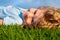 Portrait of a smiling little boy lying on green grass and dreaming. Cute child enjoying nature outdoors. Healthy