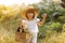 Portrait of smiling little girl walks in the rays of a sunset in a flowering meadow, enjoying the summer, warmth