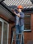 Portrait of smiling male carpenter making building house rooftop