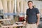 Portrait of smiling male owner of industrial small business woodworking workshop, man looking at the camera