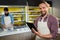 Portrait of smiling male staff using digital tablet near meat counter