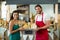 Portrait of smiling male staff and woman holding a basket of baguettes at counter