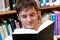 Portrait of a smiling male student reading a book