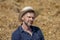 Portrait of a smiling man 35-40 years old with a beard in a straw hat on a field with hay. Concept: farming and agriculture, summe