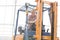 Portrait of smiling man sitting in forklift at greenhouse