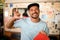 portrait of smiling man wearing cap and t-shirt and showing hand gesture