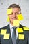 Portrait of smiling mature businessman with blank yellow adhesive notes on face and suit at office