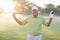 Portrait of smiling mature golfer carrying golf club