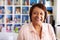 Portrait Of Smiling Mature Woman In Home Office By Bookcase