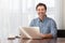 A portrait of a smiling middle-aged bearded man at a desk