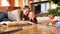 Portrait of smiling mother with her little son lying on wooden floor under Christmas tree and playing with toy railroad