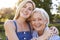 Portrait Of Smiling Mother Hugging Adult Daughter Outdoors In Summer Park