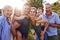 Portrait Of Smiling Multi Generation Family Outdoors In Summer Park Against Flaring Sun