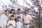 Portrait of a smiling multi-generational family amongst the cherry trees and enjoying the park in the springtime