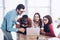 portrait of smiling multicultural business people working on laptop together