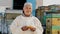 Portrait of smiling old farmer man hold container with honey, production organic