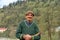 Portrait of a smiling old man in the mountains of georgia. A man with an ax is gathering firewood