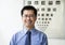 Portrait of smiling optometrist with an eye chart in the background