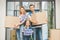 portrait of smiling parents and daughter with our new house board in hands moving