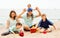 Portrait of smiling parents and their children on sand