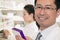 Portrait of smiling pharmacist holding prescription medication and looking at camera