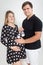 Portrait of smiling pregnant couple posing with small baby boots