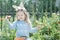 Portrait of smiling preschooler blonde girl with Easter bunny DIY ears and fresh carrots