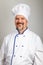Portrait of a smiling professional chef cook man dressed a chef uniform, grey background