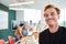 Portrait of smiling redhead businessman with team discussing in conference room at office