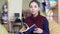 Portrait of smiling romantic female student thumbing through a book in reading room