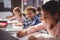 Portrait of smiling schoolboy doing his homework in classroom