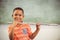 Portrait of smiling schoolboy playing flute in classroom