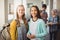 Portrait of smiling schoolgirls standing in corridor