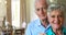 Portrait of smiling senior couple posing together in living room