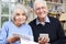 Portrait Of Smiling Senior Couple Reviewing Home Finances