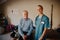 Portrait of smiling senior man with young doctor in uniform and stethoscope looking at camera