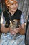 Portrait of smiling senior woman 80 years old in traditional rural headscarf and holding tabby cat on laps