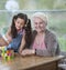 Portrait of smiling senior woman with granddaughter playing with alphabet blocks at home